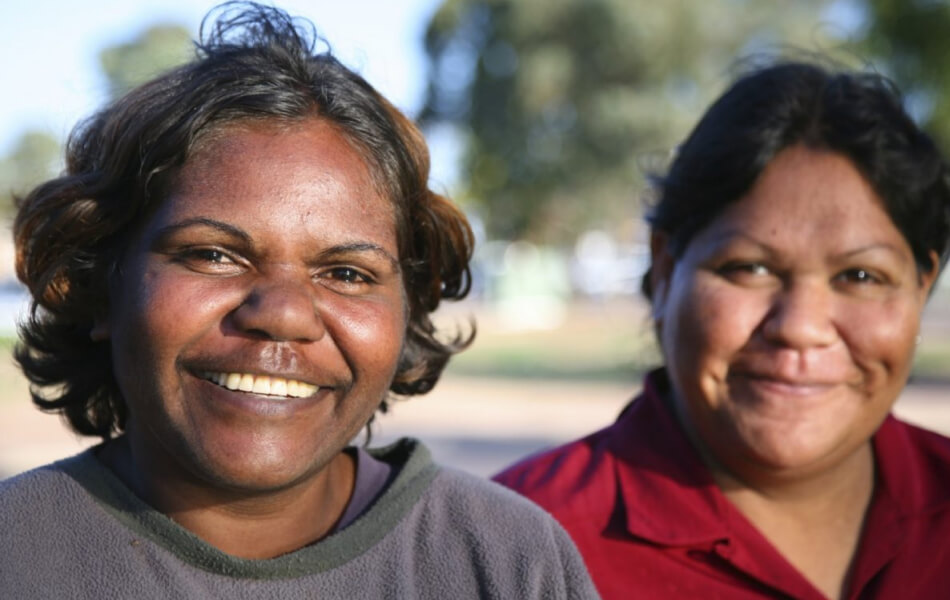 two aboriginal woman smiling at the camera